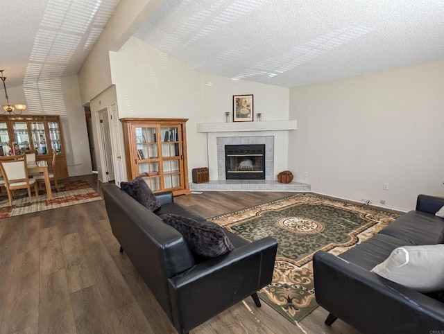 living area featuring a textured ceiling, a fireplace, vaulted ceiling, and wood finished floors