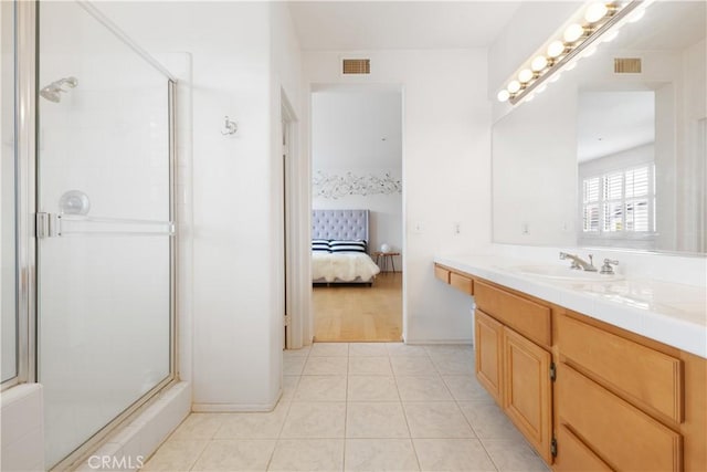 ensuite bathroom featuring a stall shower, visible vents, vanity, and tile patterned floors