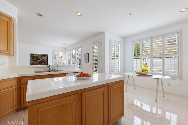 kitchen with recessed lighting, light tile patterned flooring, a sink, and tile countertops