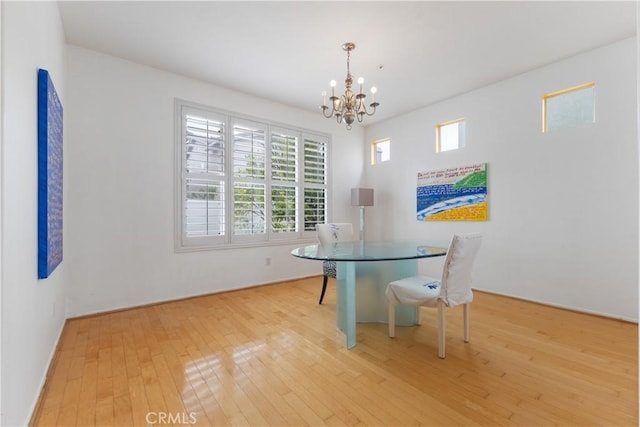 unfurnished dining area featuring light wood-style flooring and a notable chandelier