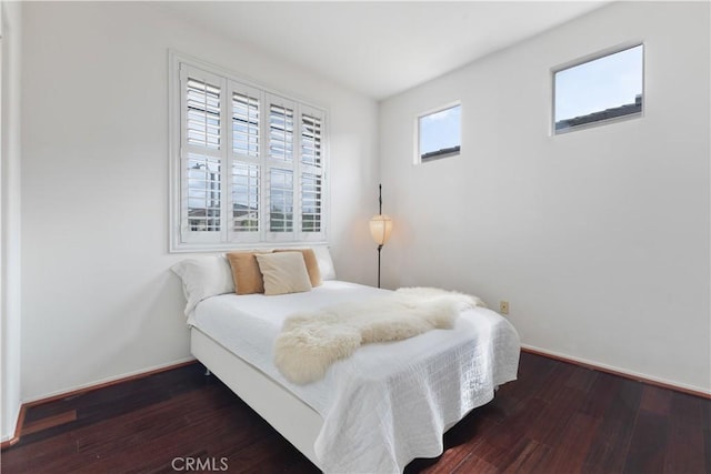 bedroom with baseboards and wood finished floors