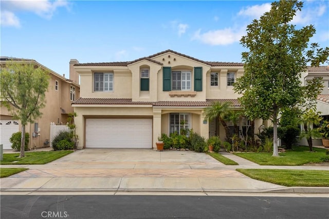 mediterranean / spanish-style house with a garage, driveway, a tile roof, and stucco siding