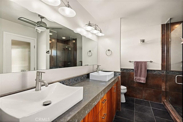 full bath featuring a stall shower, tile patterned flooring, a sink, and tile walls