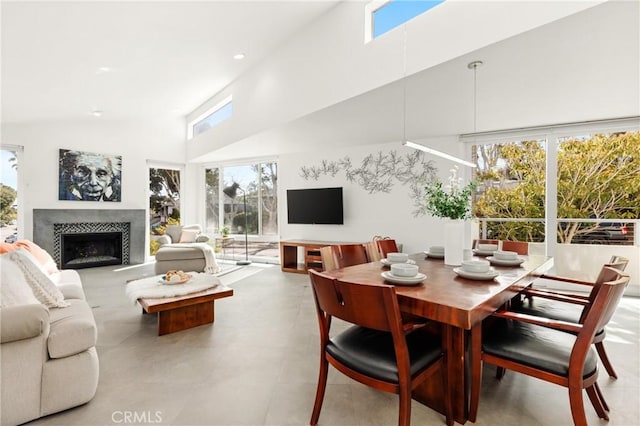 living area with recessed lighting, a fireplace, and a towering ceiling