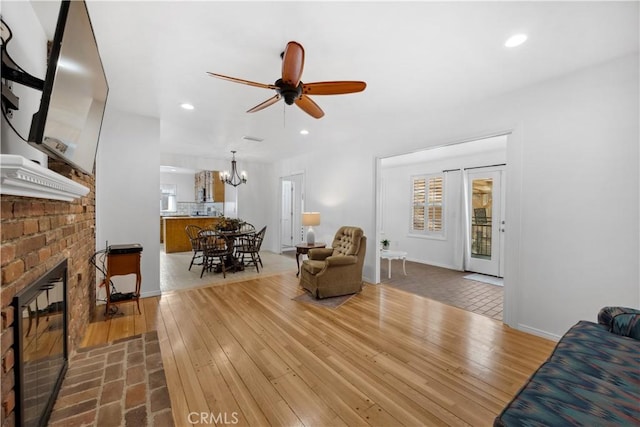 living room featuring recessed lighting, a brick fireplace, and hardwood / wood-style floors