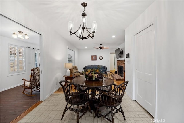 dining room featuring brick floor, recessed lighting, a brick fireplace, and baseboards