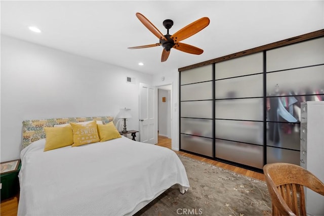 bedroom with ceiling fan, visible vents, wood finished floors, and recessed lighting