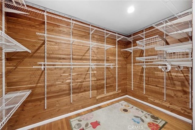 walk in closet with wood finished floors