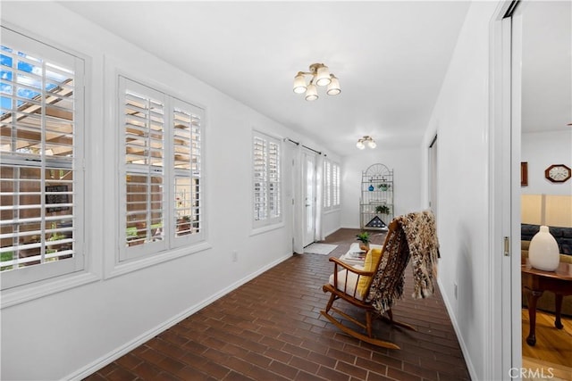 foyer entrance with brick floor and baseboards