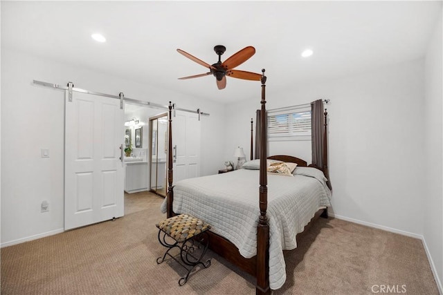 bedroom with ceiling fan, a barn door, recessed lighting, light carpet, and baseboards