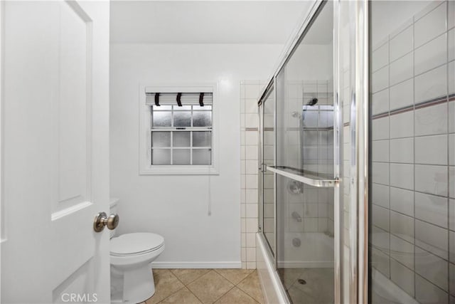 full bath featuring bath / shower combo with glass door, toilet, and tile patterned floors