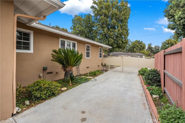 view of home's exterior featuring crawl space, a patio area, fence, and stucco siding