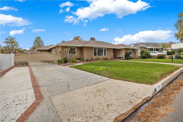 single story home featuring fence, concrete driveway, a gate, stucco siding, and a front lawn