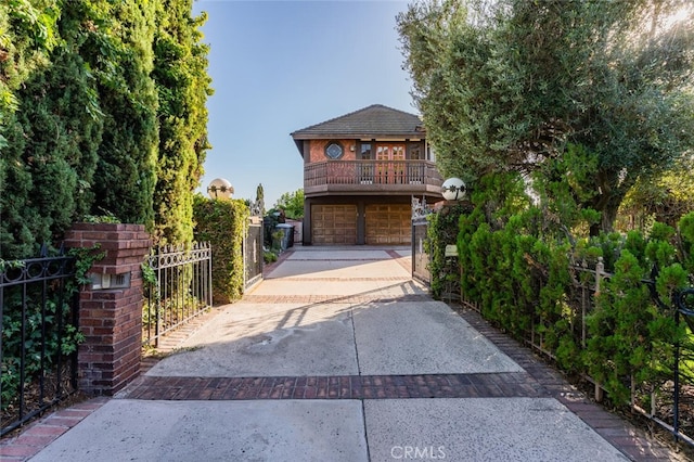 view of front facade featuring a garage, concrete driveway, and a gate