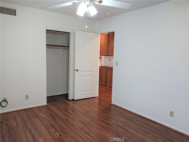 unfurnished bedroom with baseboards, visible vents, a ceiling fan, dark wood finished floors, and a closet