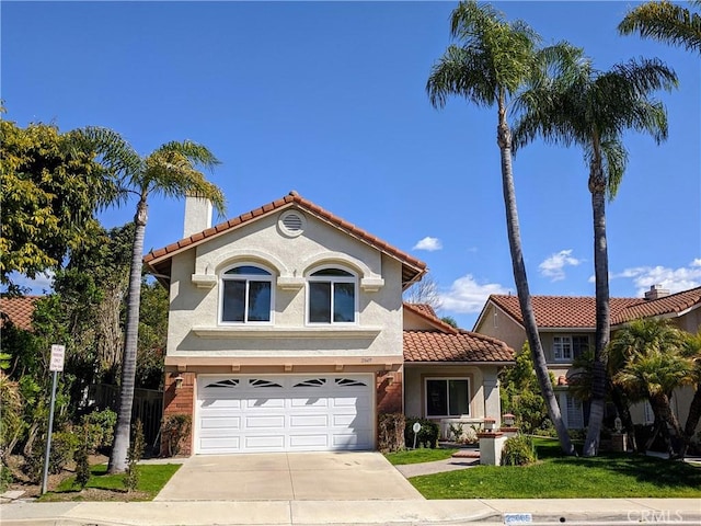 mediterranean / spanish home with driveway, a chimney, a tiled roof, an attached garage, and stucco siding