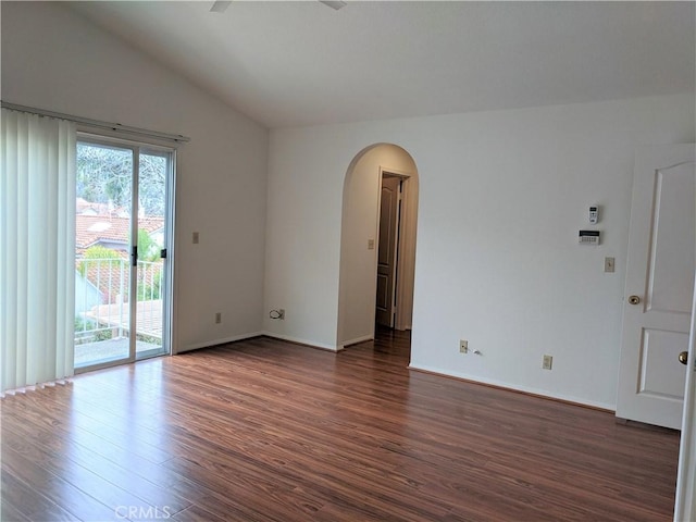 unfurnished room with arched walkways, ceiling fan, dark wood-type flooring, baseboards, and vaulted ceiling