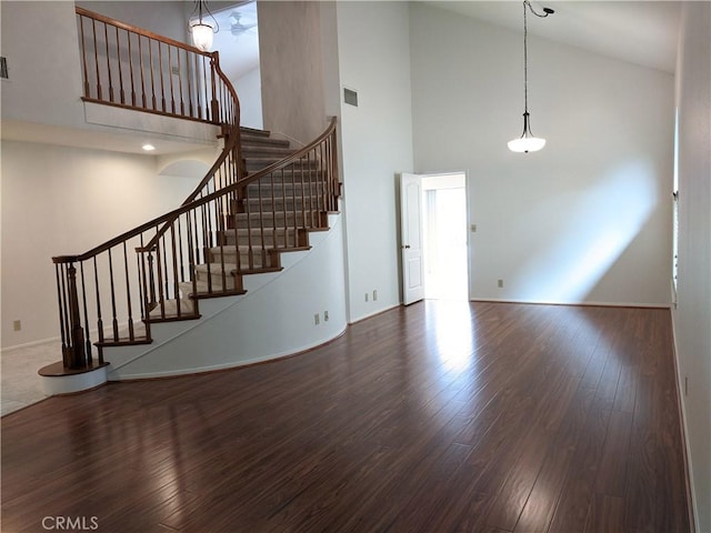 unfurnished living room featuring high vaulted ceiling, visible vents, stairs, and wood finished floors