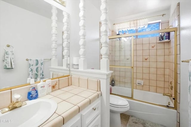 full bath with enclosed tub / shower combo, vanity, and toilet