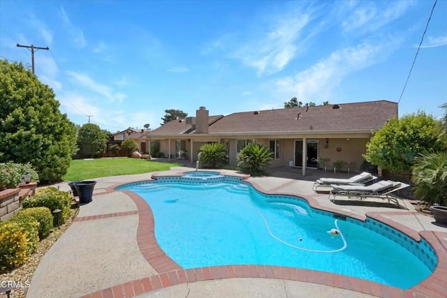 view of swimming pool with a pool with connected hot tub, a lawn, and a patio