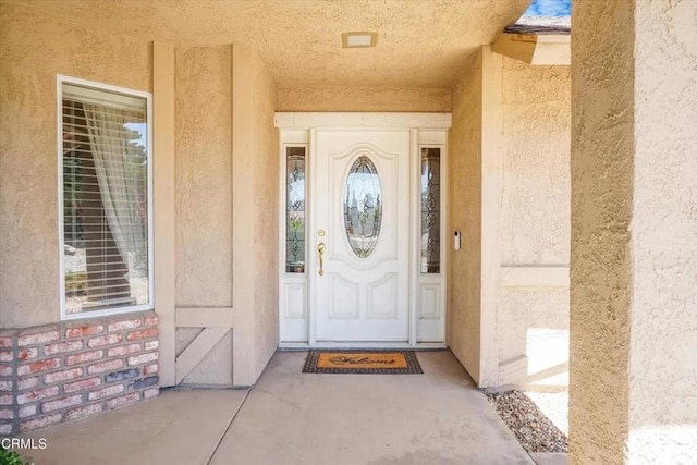 property entrance with stucco siding