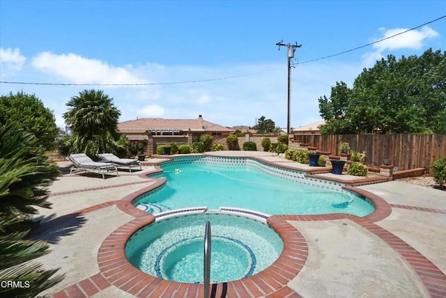 view of pool with a pool with connected hot tub, fence, and a patio