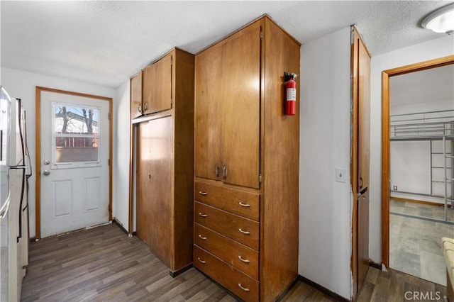 interior space with a textured ceiling and wood finished floors