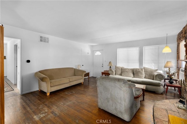 living area featuring dark wood-type flooring and visible vents