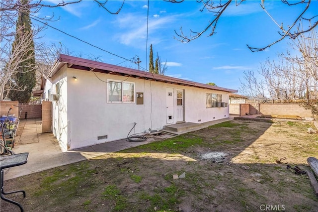 back of house with crawl space, fence, and stucco siding