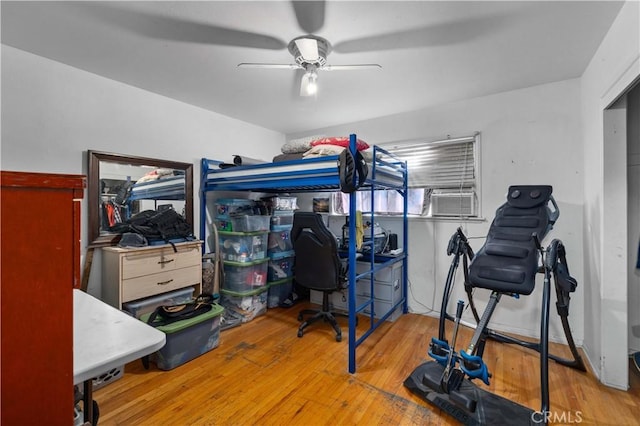 bedroom featuring ceiling fan, cooling unit, and wood finished floors