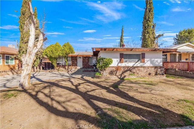 ranch-style home with brick siding and stucco siding