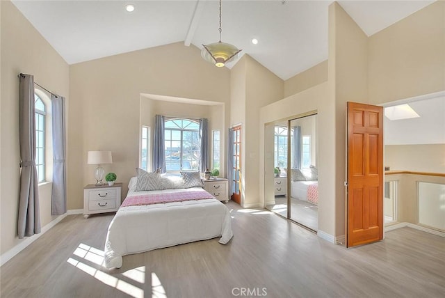 bedroom with high vaulted ceiling, beamed ceiling, baseboards, and wood finished floors