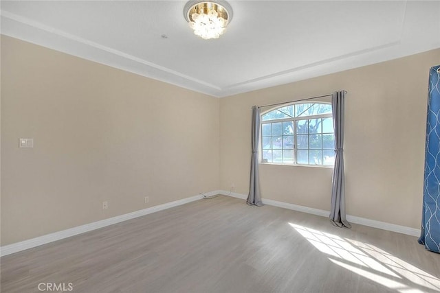 spare room with light wood-style floors and baseboards