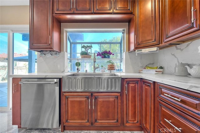 kitchen with dishwasher, light countertops, backsplash, and a sink