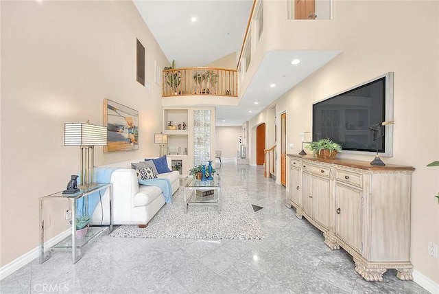 living room with arched walkways, recessed lighting, granite finish floor, a high ceiling, and baseboards