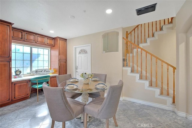 dining space featuring visible vents, baseboards, and stairs