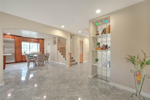 interior space with arched walkways, stairway, recessed lighting, and baseboards