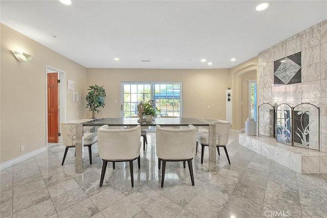 dining space with a tile fireplace, baseboards, and recessed lighting