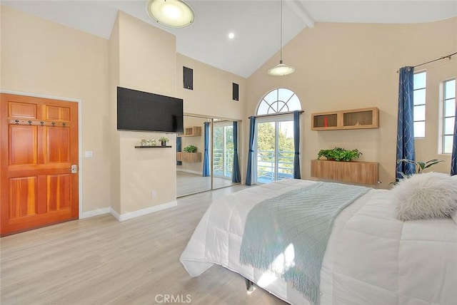 bedroom with access to outside, multiple windows, light wood-style flooring, and beamed ceiling