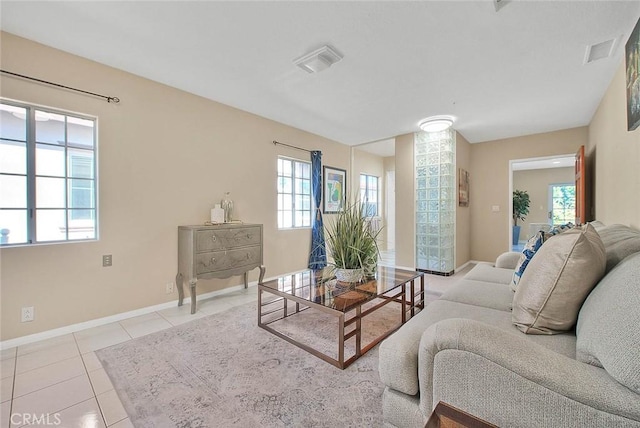 living room with tile patterned flooring, visible vents, and baseboards