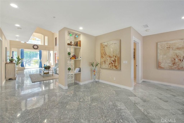 foyer entrance with recessed lighting and baseboards