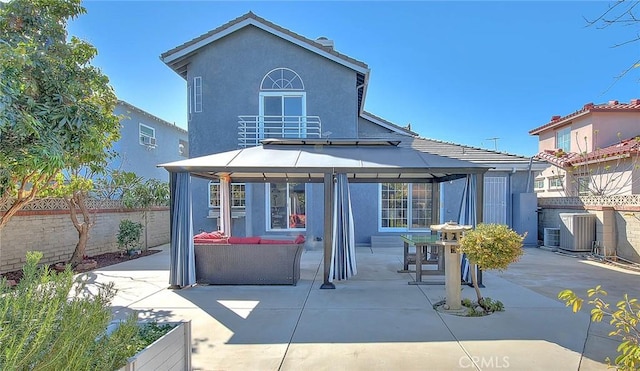 back of property with stucco siding, fence, a patio, and a gazebo