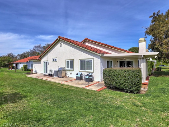 27740 Via Sarasate, Mission Viejo, CA 92692 - rear view of house featuring a patio, a chimney, a yard, stucco siding, and a tiled roof