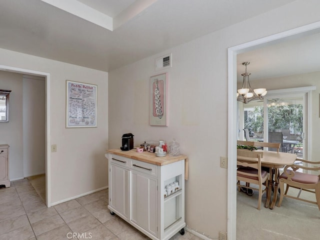 27740 Via Sarasate, Mission Viejo, CA 92692 - kitchen with white cabinets, a chandelier, butcher block counters, and light tile patterned flooring