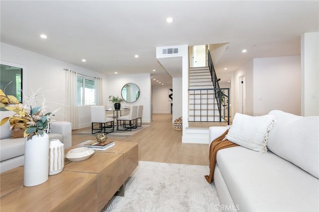 living room featuring light wood finished floors, stairway, visible vents, and recessed lighting