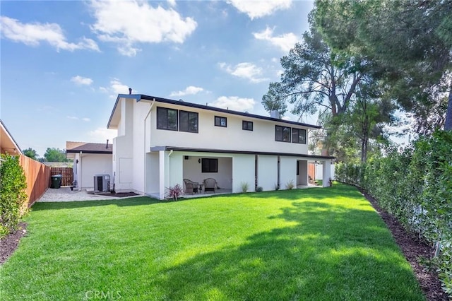 rear view of property featuring a patio, central AC unit, a fenced backyard, a lawn, and stucco siding