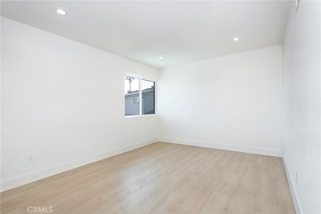 unfurnished room featuring light wood-type flooring, baseboards, and recessed lighting