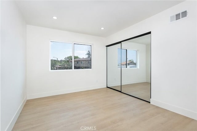 unfurnished bedroom featuring light wood-type flooring, visible vents, baseboards, and recessed lighting