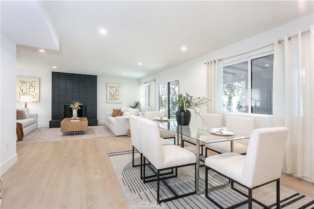 living room with recessed lighting, a fireplace, light wood-style flooring, and baseboards