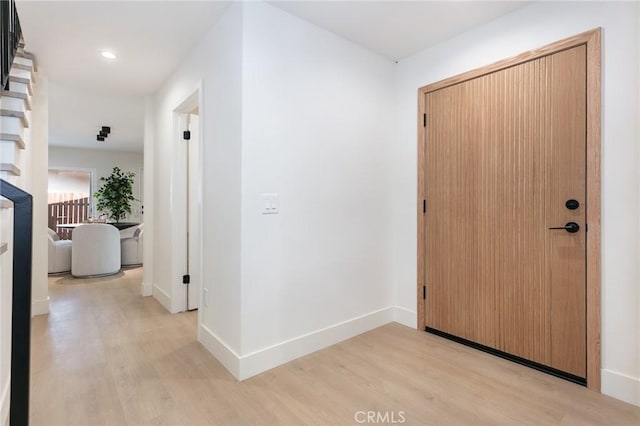 corridor with recessed lighting, light wood-style flooring, and baseboards